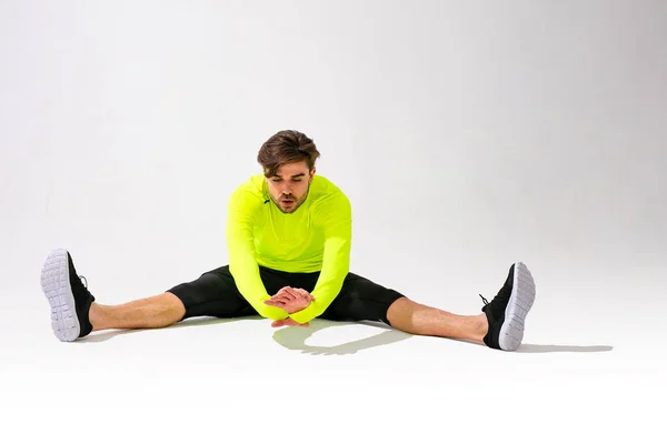 Haciendo Estiramientos Primero Joven Entrenamiento Ropa Deportiva Estirando Músculo Sobre —  Fotos de Stock