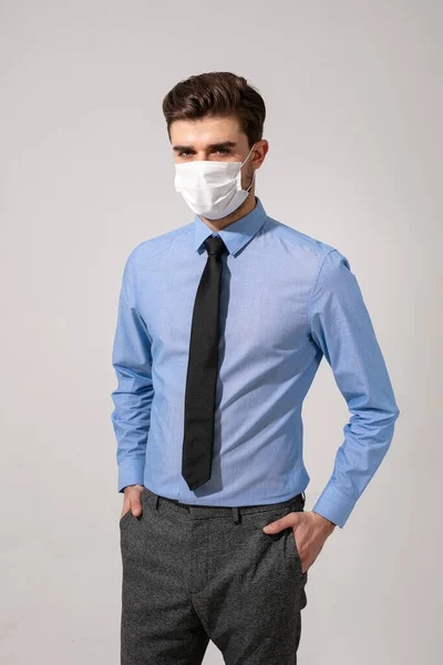 outfit with virus protection. elegant man with tie wearing a mouth protection against contagious diseases