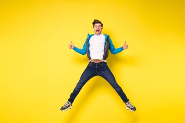 Mid-air shot of handsome young man jumping and gesturing, showing excitment clipart