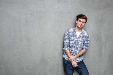 Endüstriyel beton duvarın karşısında duran kendine güvenen modern ve havalı adam