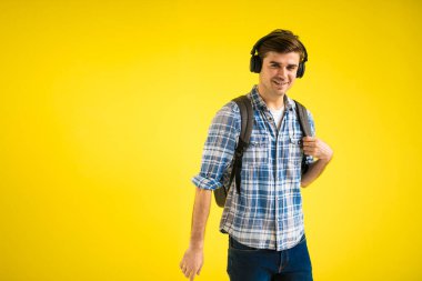 Sakin ve sakin bir adam sarı arka planda müzik dinliyor.