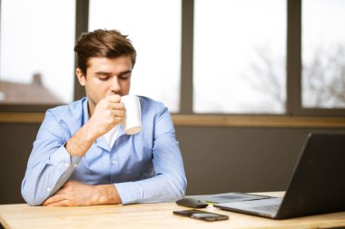 Uzaktan kumandalı, yakışıklı, önlerinde dizüstü bilgisayarı olan, pozitif tavırlı genç adamlar.