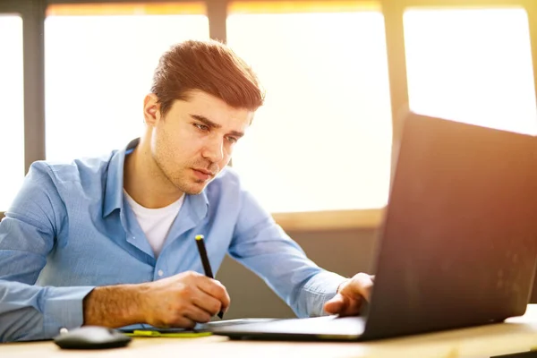 Porträtt Ung Man Sitter Vid Sitt Skrivbord Kontoret Fokuserad Arbetar — Stockfoto