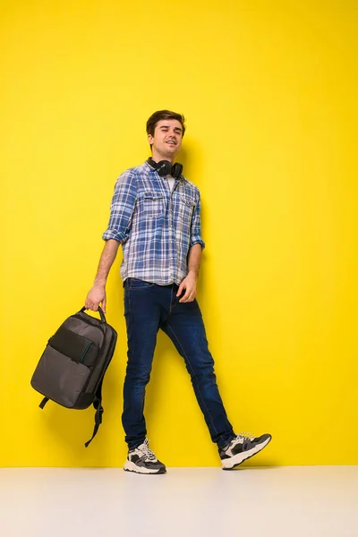 Pohledný Muž Pózuje Žlutém Pozadí Sluchátka Batoh — Stock fotografie