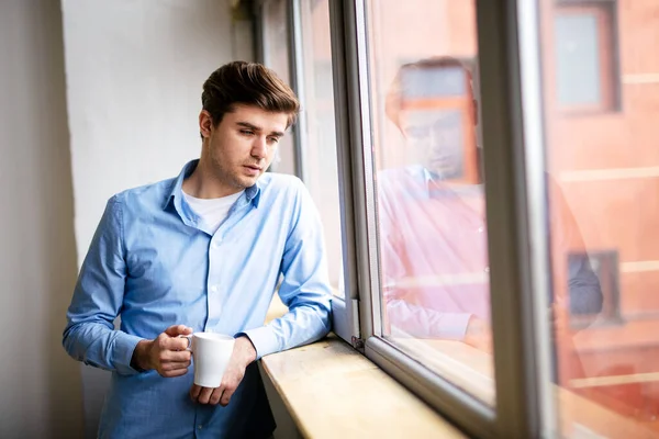 家にいて 窓の横に立った正装の青年 — ストック写真
