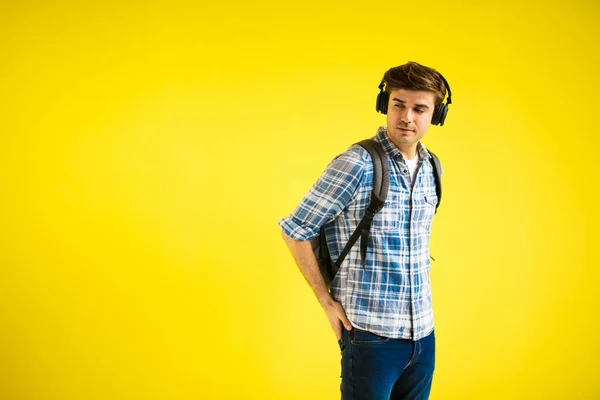 cool and relaxed man on yellow background listening music