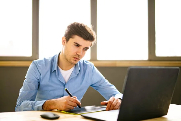 Ritratto Giovane Seduto Alla Scrivania Ufficio Concentrato Mentre Lavora Qualche — Foto Stock