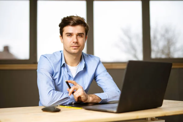 working remote, handsome young men sitting at desk with laptop in front, with positive attitude