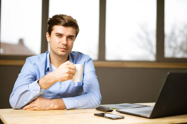 Yakışıklı Bir Adam Girişimci Ofis Masasında Laptopuyla Kahve Içiyor — Stok fotoğraf