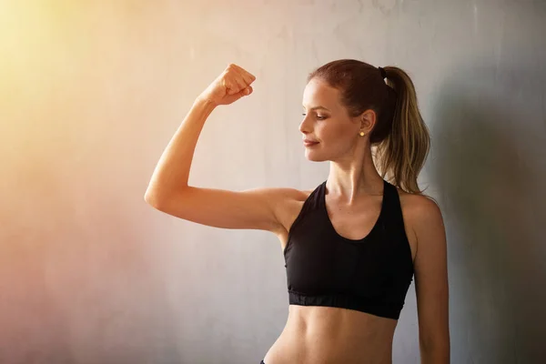 portrait of a young sportive and active woman in industrial fitness gym