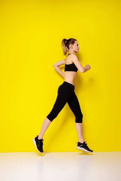 Sarı Arka Planda Siluetli Bir Kadın Koşucu Çekici Bir Kadının — Stok fotoğraf