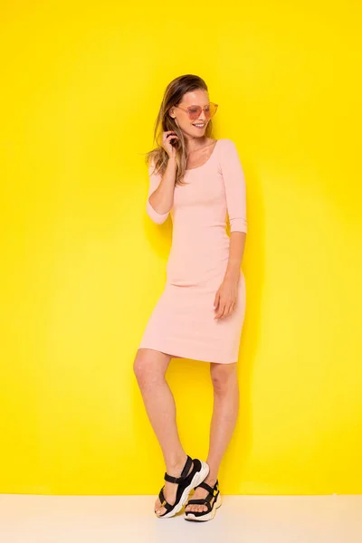 Genç Modern Kadın Seksi Elbiseli Sarı Arka Planda Sevinçle Poz — Stok fotoğraf