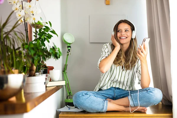 Glückliche Alleinstehende Frau Kommuniziert Und Hört Musik Auf Dem Schreibtisch lizenzfreie Stockfotos