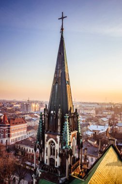 Lviv 'deki katedral kulesinin tepesinde, arka planda günbatımı gökyüzü var.