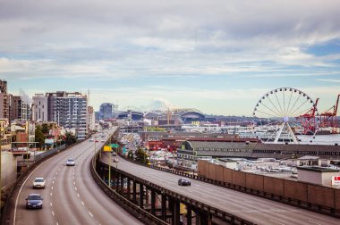 Çok şeritli otoyol ve panoramik Seattle Büyük Tekerleği. Arka planda bulutlu bir gökyüzü ve yazın sonunda sakin ve ılık bir hava.