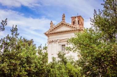 Mavi bulutlu gökyüzü ile ağaçların arasındaki antik katedrale bak