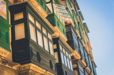 Arka planda mavi gökyüzü olan Malta balkonları