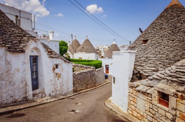 Alberobello 'da caddenin köşesinde küçük bir bina.