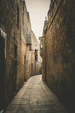 Güneş ışınlarıyla antik binalar arasındaki dar karanlık cadde