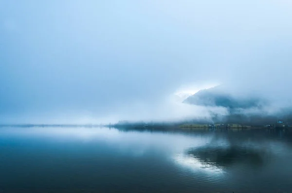 Temprano niebla mañana húmeda en el lago entre las montañas en Au — Foto de Stock