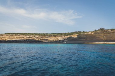 Arka planda mavi gökyüzü olan deniz kıyısı