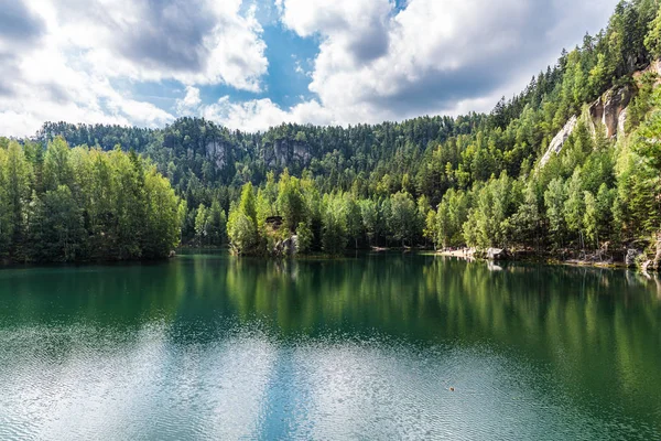 Grünes Wasser des ruhigen Waldsees zwischen kleinen Bergen — Stockfoto