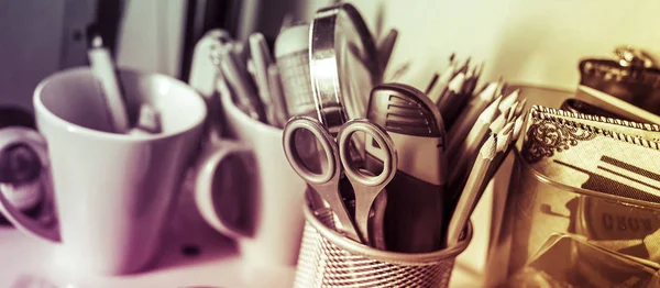 Writing instruments in glasses on a shelf. — Stock Photo, Image