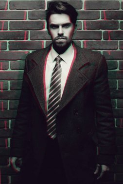 Sakal poz açık havada uzağa arıyorsunuz ile moda iyi giyimli adam portresi, kendinden emin ve odaklanmış olgun erkek ceket daimi bir tuğla üzerinde duvar arka plan, şık moda modeli.