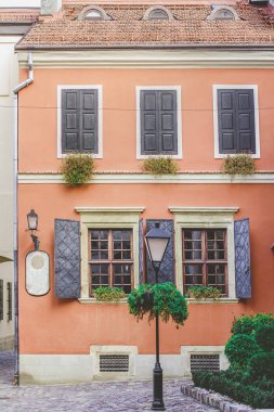 Şehrin eski avluda bir portakal arka plan üzerinde eski windows duvar.