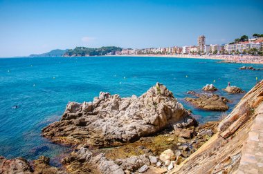 panoramik deniz kıyısı rock cliff ve bir kasaba ile arka plan üzerinde