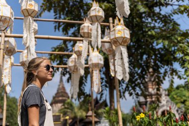 Güzel sarışın kız kutlama sırasında Tayland 'daki Budist tapınağında geziyor.