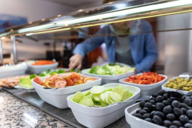 Sağlıklı yemek, zeytin ve salata tabakları ve yiyecek toplayan odaklanmamış arka planda bir adamın stok fotoğrafı. Yaşam biçimi