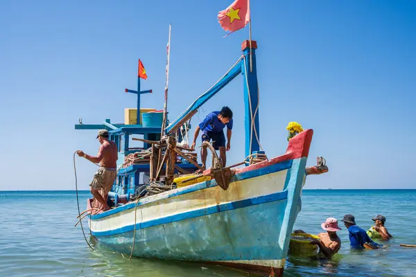 Phu Quoc, Vietnam, 24 de diciembre de 2019: Pescadores que trabajan en un barco pesquero que transporta pescado en cestas. — Foto de Stock