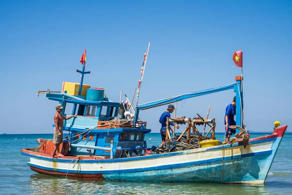 Phu Quoc, Vietnam, 24 de diciembre de 2019: Tres pescadores vietnamitas en un barco de madera. — Foto de Stock