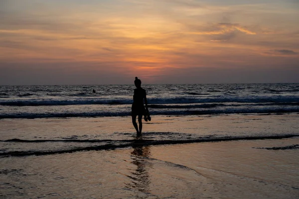 인도네시아에서 태양이 내려가면서 그녀의 해변에 소녀의 실루엣 — 스톡 사진