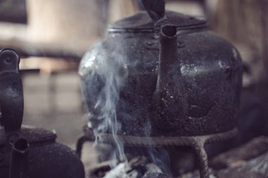 Tayland 'daki odun ateşinde siyah çaydanlık ısınıyor.
