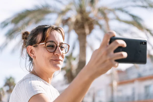 Mujer Con Gafas Cabello Atado Haciendo Una Selfie Afuera Medio Imágenes de stock libres de derechos