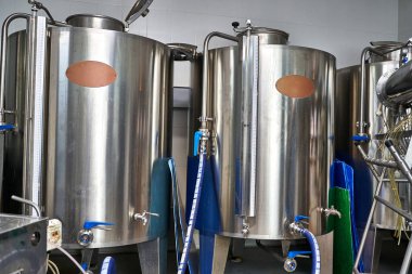 Bira fabrikasında metal silindir şeklinde kaplar var. Bira fabrikası konsepti