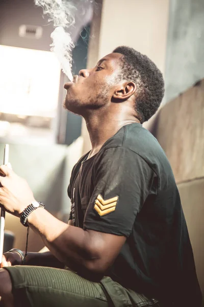 Foto Vertical Del Perfil Joven Negro Fumando Soplando Humo Una Imagen de stock