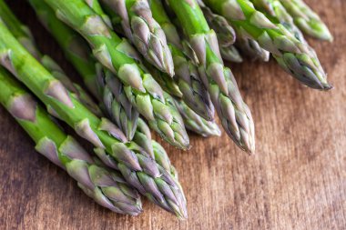 Makro yakın plan yeşil kuşkonmaz koyu ahşap masa üzerinde, yatay fotokopi alanı ile