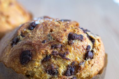 Panettone 'un ahşap zemin üzerinde çikolata parçacıkları olan yakın plan görüntüsü.