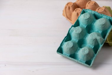 Beyaz ahşap üzerinde yeşil, kahverengi ve sarı altı yumurta için boş kutular üst görünüm, geri dönüşüm için hazırlanmış, yatay olarak kopyalama alanı ile