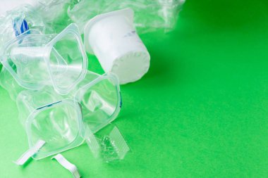 Yeşil zemin üzerinde plastik kapların yakın plan, geri dönüşüm için hazır, kopya alanı ile yatay olarak