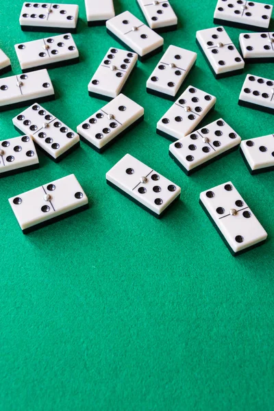 Yeşil hasırda oynanacak birçok domino taşının üst görünümü, dikey olarak kopyalama alanı ile