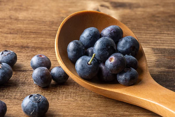 蓝莓木勺与暗色木板的特写 蓝莓与蓝莓的对焦不平整 — 图库照片