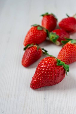 Dikey metin için seçici odak ve alan ile beyaz arkaplan üzerindeki çileklerin üst görünümü