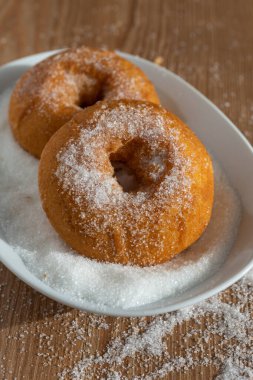 Tabakta iki çörek, tahta tahtada şeker ve kopyalanmış alanla dikey olarak şeker.