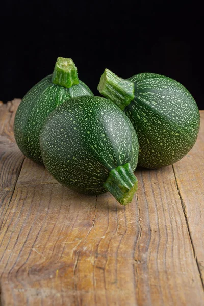 Kırsal ahşap tahtada üç yuvarlak kabağın üst görüntüsü ve dikey arkaplan