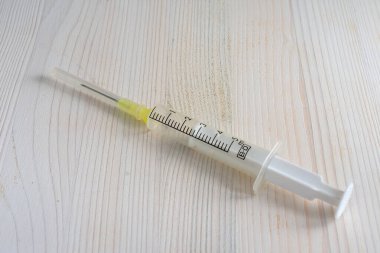 Beyaz tablo üzerindeki şeffaf plastik şırınganın üst görünümü kopya alanı ile yatay olarak