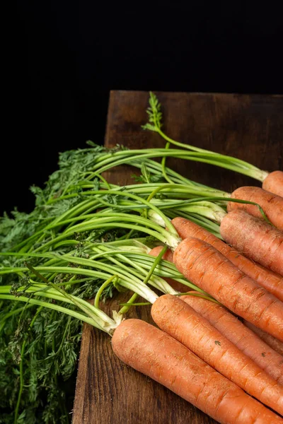 Top View Carrots Green Leaves Wooden Board Black Background Vertical — Stock Photo, Image